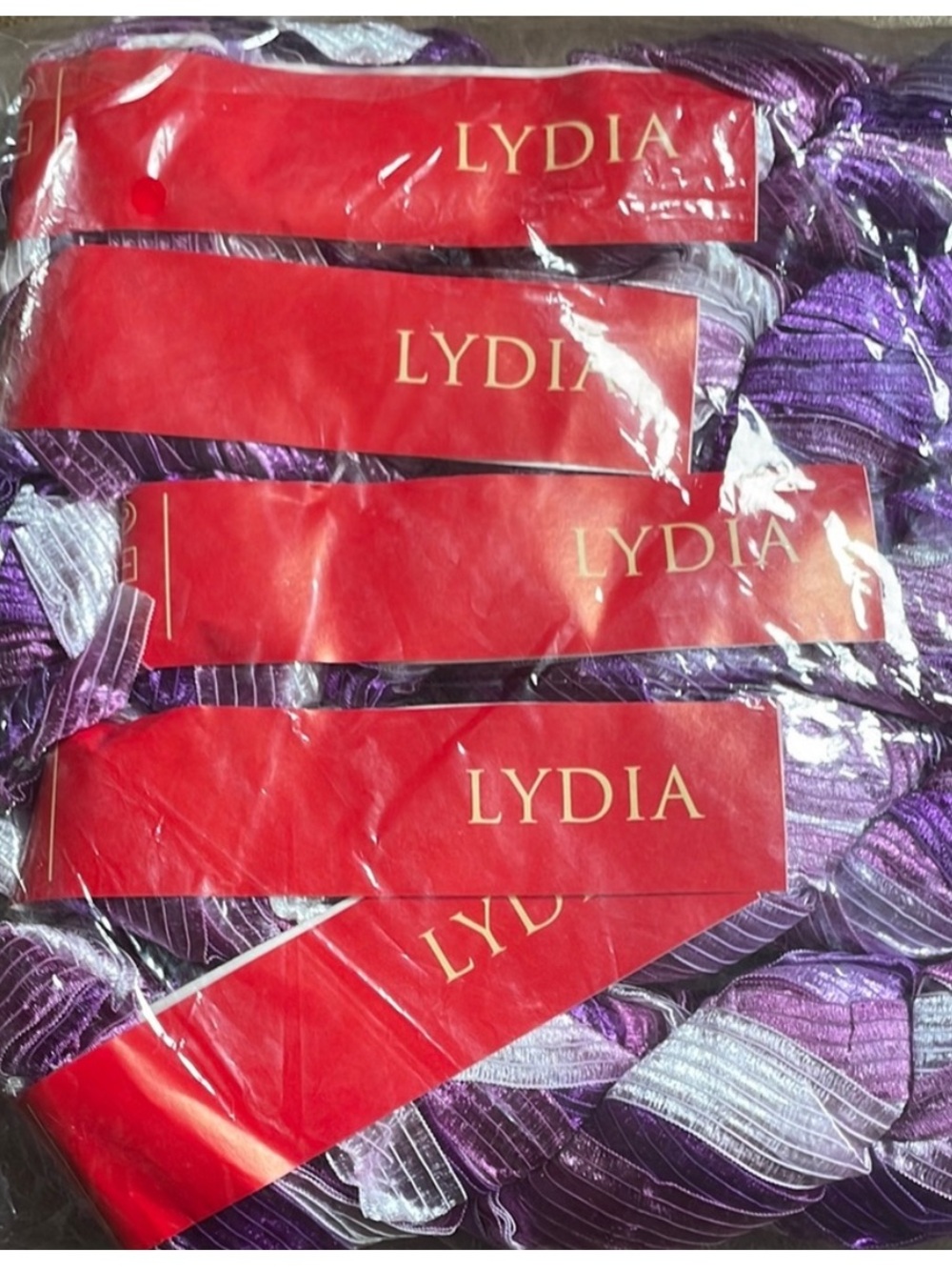 Pack of Lydia yarn in purple and white. Perfect for knitting and crafting.
